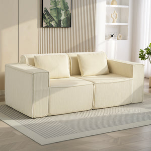 Three-seater corduroy sofa with deep seat, wide armrests, and two cushions, beige.