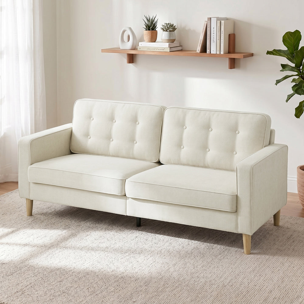 Tufted 3-seater sofa with upholstered cushions and wooden legs, cream white.