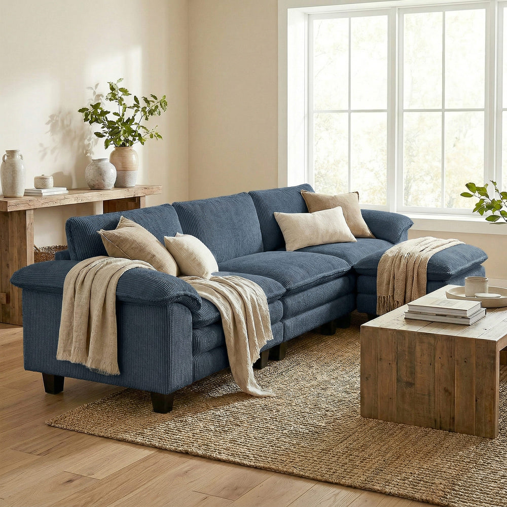L-shaped sofa with deep seating, removable ottoman, and padded armrests, blue
