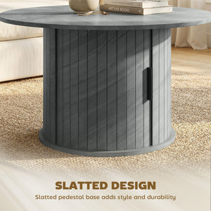 Round coffee table with fluted base and hidden sliding door storage – Cement gray