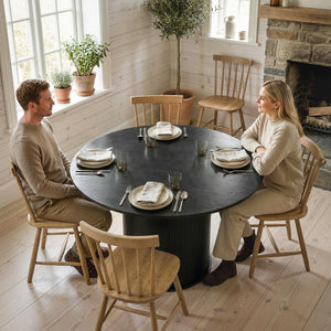 Round black dining table for 5 with fluted central pedestal.
