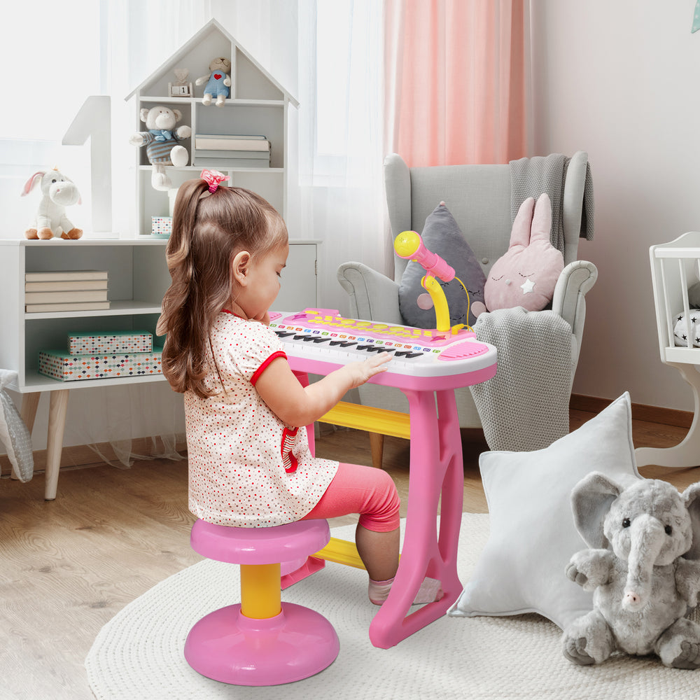 Piano keyboard with stool, working microphone and bright flashlight, pink