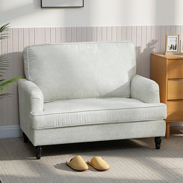 Modern faux leather accent chair with turned legs and wide seat, cream white